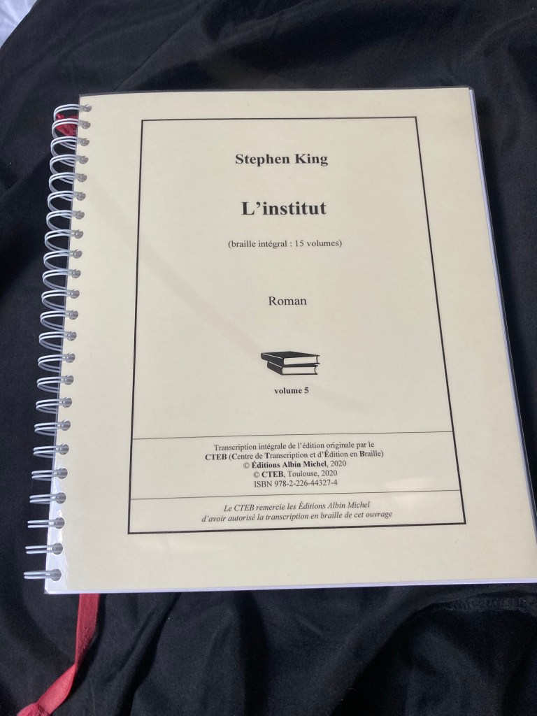 Sur un fond noir: le volume 5 en braille de L’Institut de Stephen King. Une espèce de ficelle rouge en dépasse.