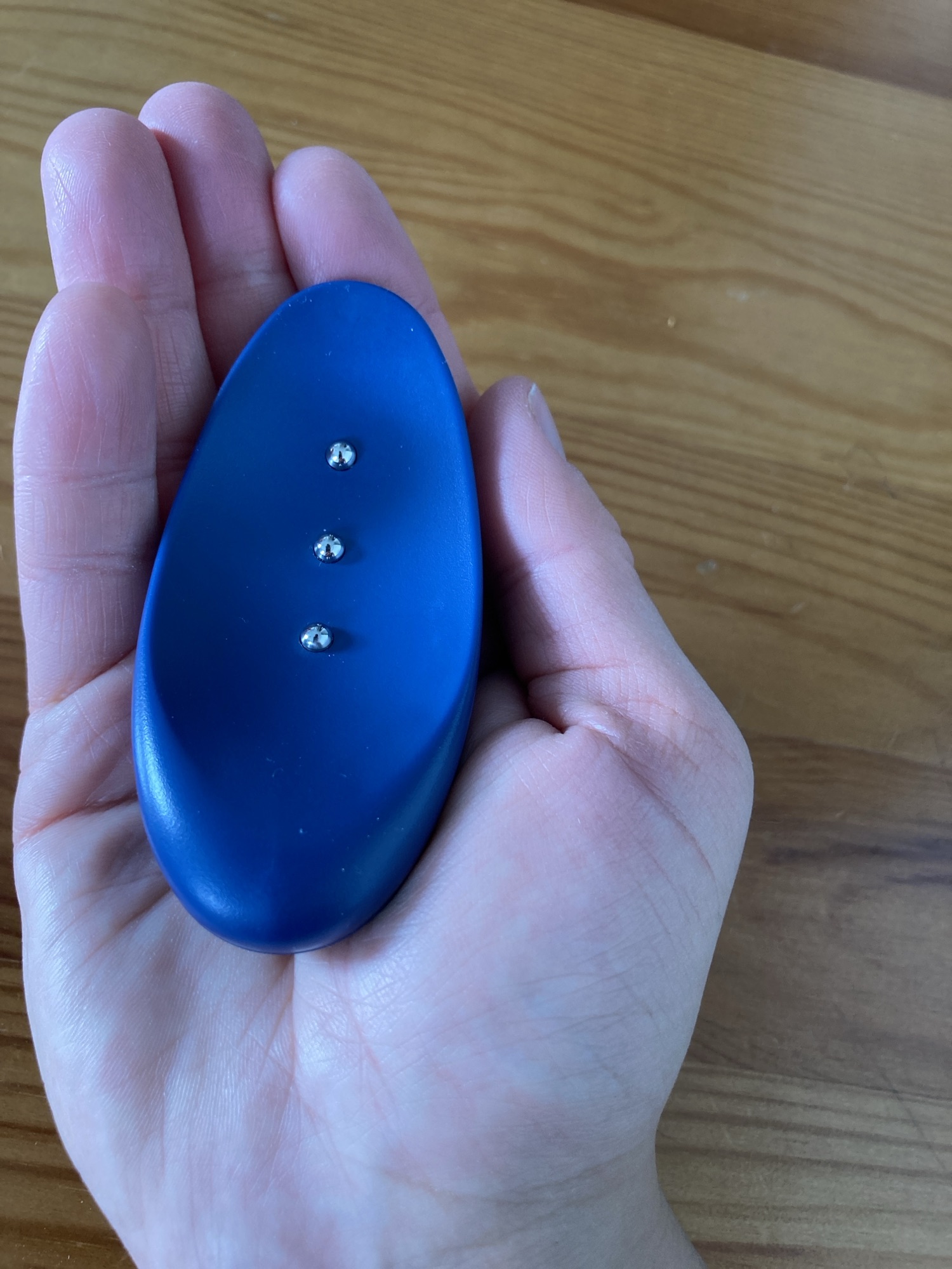 Ilékéleur tient dans sa main droite un objet bleu oval avec 3 boutons placés sur toute la longueur.