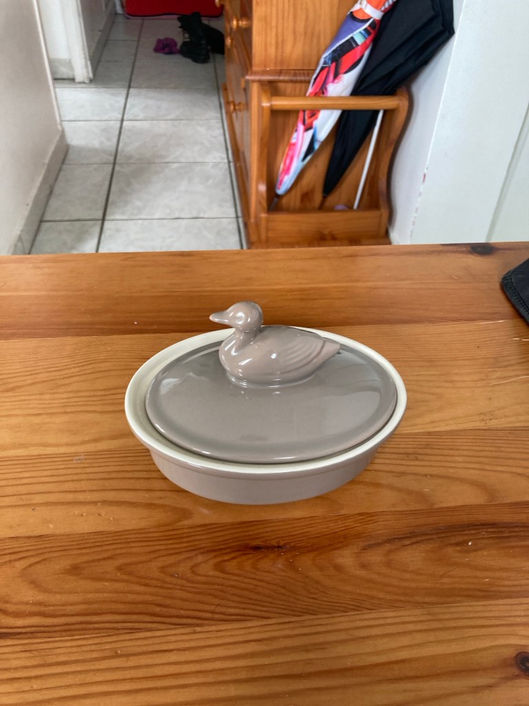 Un pot ovale en céramique avec sur le couvercle un canard.