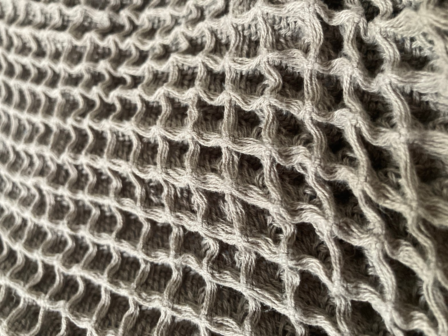 Gros plan sur une serviette grise en nid d’abeille.